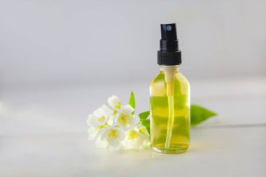 Çiçeklerin özü beyaz bir arka planda güzel bir cam kavanozda