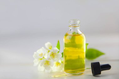 Çiçeklerin özü beyaz bir arka planda güzel bir cam kavanozda