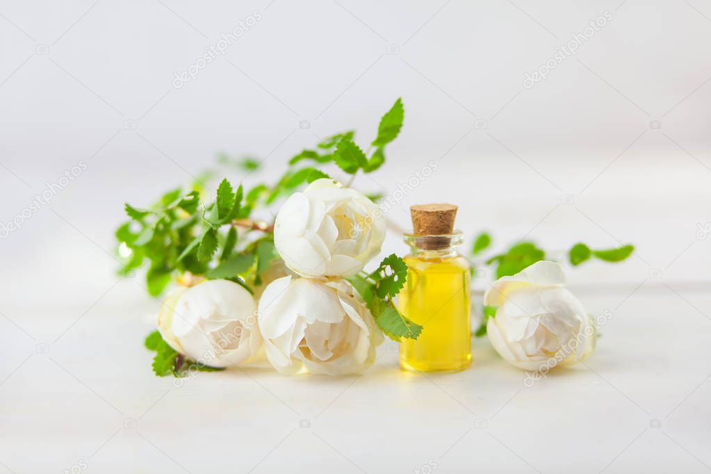 Essence of flowers on a white background in a beautiful glass jar