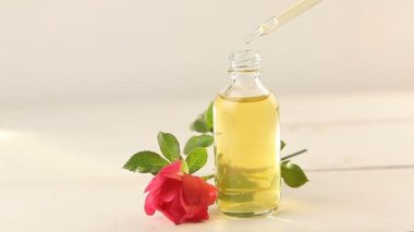 Güzel cam şişe içinde beyaz zemin üzerine gül özü