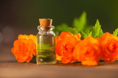 Çiçeklerin özü güzel bir cam şişede masanın üzerinde.