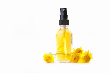 Çiçeklerin özü güzel bir cam şişede masanın üzerinde.