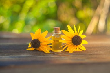 Çiçeklerin özü güzel bir cam şişede masanın üzerinde.