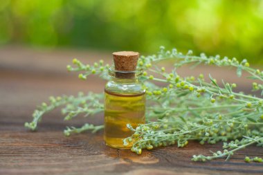 Çiçeklerin özü güzel bir cam şişede masanın üzerinde.