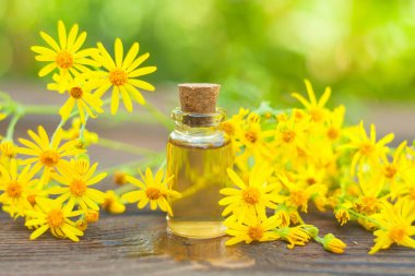 Çiçeklerin özü güzel bir cam şişede masanın üzerinde.