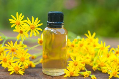 Çiçeklerin özü güzel bir cam şişede masanın üzerinde.