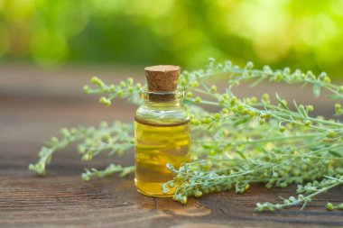 Çiçeklerin özü güzel bir cam şişede masanın üzerinde.