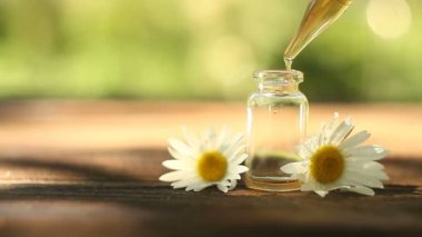 Çiçeklerin özü güzel bir cam şişede masanın üzerinde.