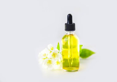 Çiçeklerin özü beyaz bir arka planda güzel bir cam kavanozda