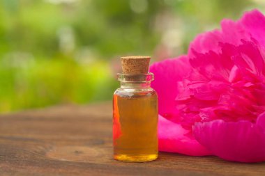 Çiçeklerin özü güzel bir cam şişede masanın üzerinde.