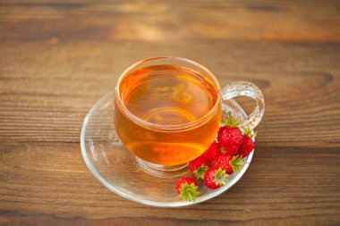 bir tabloda bir güzel cam kase lezzetli yabani çilek çay