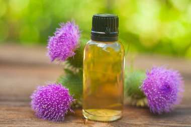 Thistle Esans güzel bir şişe masanın üzerinde
