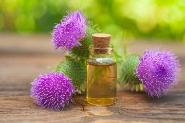Thistle Esans güzel bir şişe masanın üzerinde