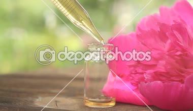 Güzel cam şişe içinde masaya Peony çiçek özü