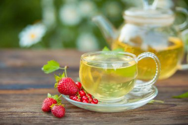 bir tabloda bir güzel cam kase lezzetli yabani çilek çay