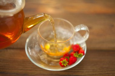 bir tabloda bir güzel cam kase lezzetli yabani çilek çay