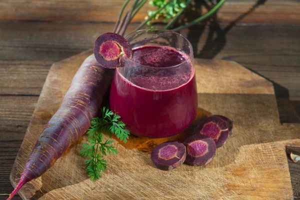 Zumo de zanahoria en vaso sobre mesa de madera — Foto de Stock