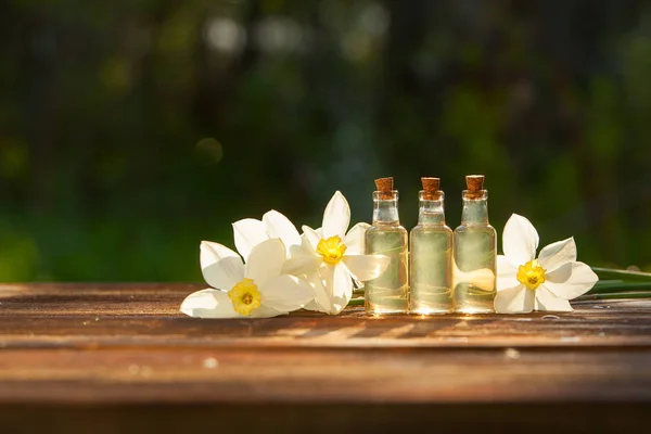 Esencia de flores en blanco en un hermoso frasco de vidrio — Foto de Stock