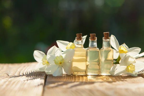 Esencia de flores en blanco en un hermoso frasco de vidrio — Foto de Stock