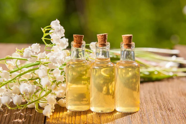 Esencia de flores en la mesa en un hermoso frasco de vidrio — Foto de Stock