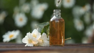 Güzel cam kavanoz ahşap arka plan üzerinde çiçek Özü