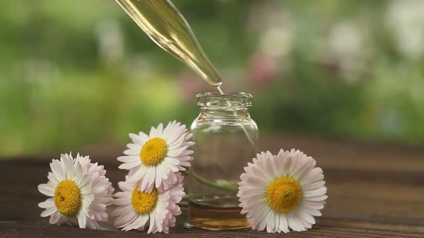 美しいガラスの瓶にテーブルの上に花の本質 — ストック動画