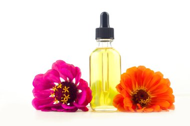 Beyaz arka plan üzerinde güzel şişe de Zinnia uçucu yağ
