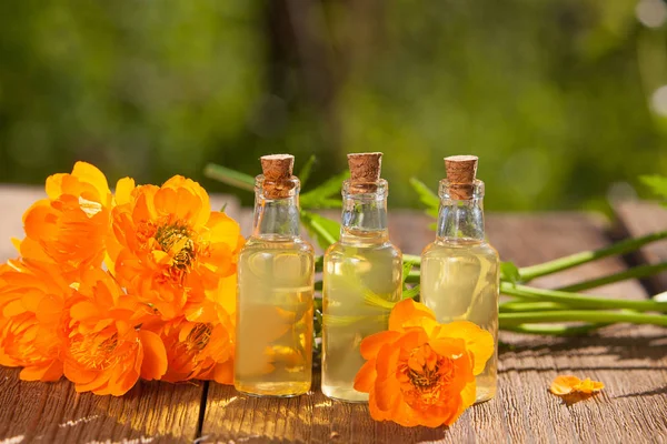 Esencia de flores de lavanda en la mesa en una hermosa botella de vidrio —  Fotos de Stock