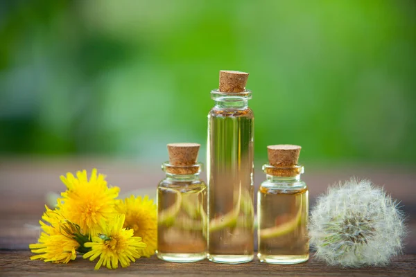 Dandelion essential oil in  beautiful bottle on table — Stock Photo, Image
