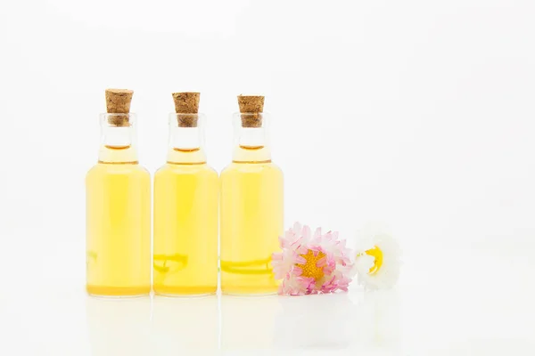 Esencia de flores en la mesa en un hermoso frasco de vidrio — Foto de Stock