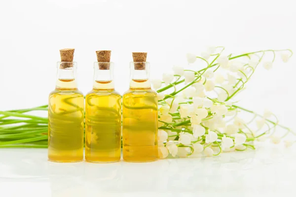 Esencia de flores en la mesa en un hermoso frasco de vidrio — Foto de Stock