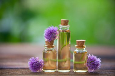 Ahşap arka plan üzerinde güzel şişe de chives esansiyel yağ