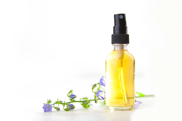 Ätherisches Glockenblumenöl in schöner Flasche auf weißem Hintergrund — Stockfoto