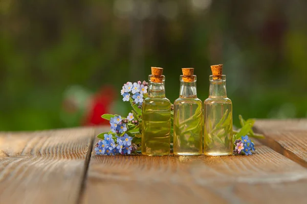 Essentie van bloemen op tafel in mooie glazen pot — Stockfoto