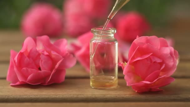 美しいガラスの瓶の中のテーブルの上のバラのエッセンス — ストック動画