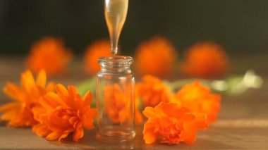 Güzel cam şişe masada calendula çiçek özü