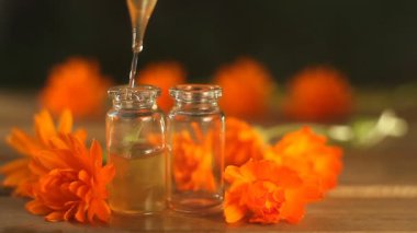 Güzel cam şişe masada calendula çiçek özü