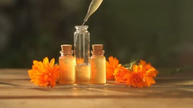 Güzel cam şişe masada calendula çiçek özü