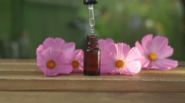 Çiçeklerin özü güzel bir cam şişede masanın üzerinde.