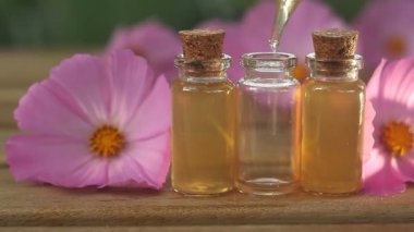 Çiçeklerin özü güzel bir cam şişede masanın üzerinde.