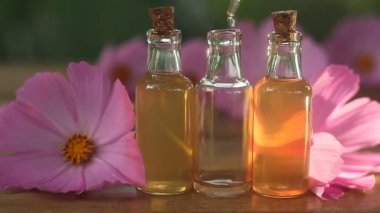 Çiçeklerin özü güzel bir cam şişede masanın üzerinde.