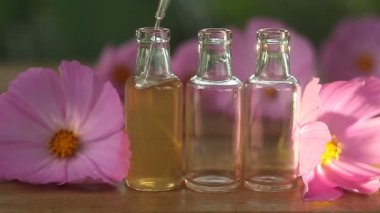 Çiçeklerin özü güzel bir cam şişede masanın üzerinde.