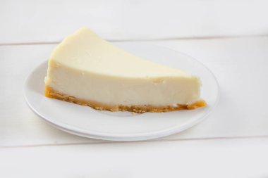 Beyaz masa üzerinde beyaz tabakta klasik cheesecake