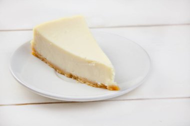 Beyaz masa üzerinde beyaz tabakta klasik cheesecake