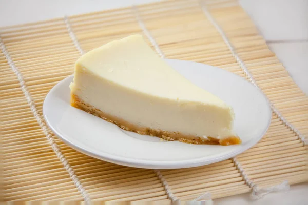 Klasický cheesecake na bílém štítku na dřevěný stůl — Stock fotografie