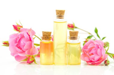 Güzel cam şişe içinde beyaz zemin üzerine gül özü