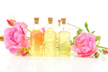 Güzel cam şişe içinde beyaz zemin üzerine gül özü