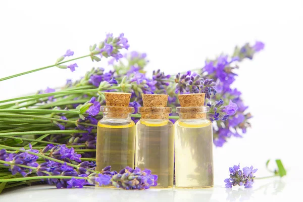 Aceite esencial de lavanda en hermosa botella sobre fondo blanco — Foto de Stock