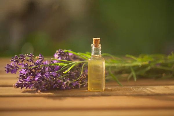 Aceite esencial de lavanda en una hermosa botella sobre la mesa — Foto de Stock