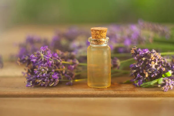 Aceite esencial de lavanda en una hermosa botella sobre la mesa — Foto de Stock